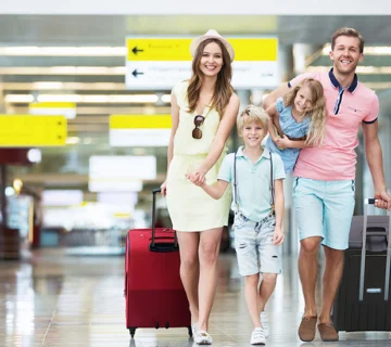 Çocuklu bir aile havalimanında valizleriyle seyahat ederken; konforlu ve güvenli havalimanı transfer hizmetleri.